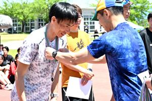 駅伝の部でメダルが授与される男性の画像