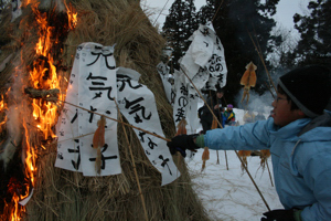 賽の神の火でするめを焼く児童の画像