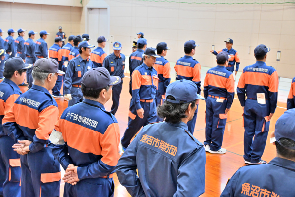 小千谷市と魚沼市の消防団員が整列して訓練をしている様子