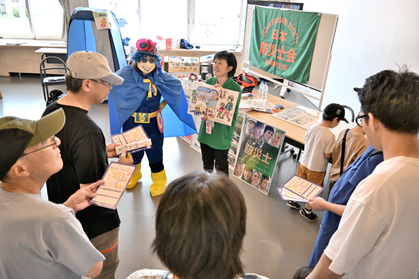 防災○×マンの話を聞く来場者たちの画像