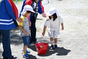 花火を水につけて消火する園児の写真
