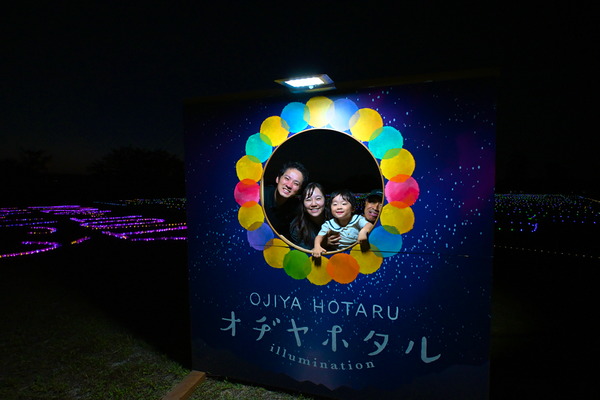 顔出しパネルで記念撮影をする家族の画像