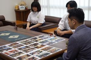 写真を見ながら報告を受ける様子