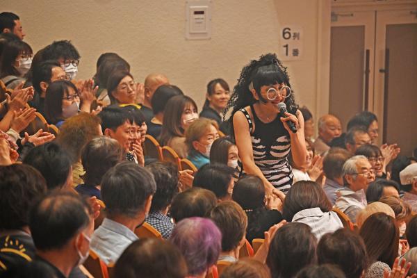 ものまねをしながら観客と握手するミラクルひかるさん