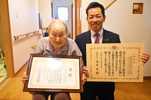 褒状を手に市長と映る100歳の女性の写真