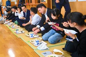 市長と小学生が防災給食を食べている画像