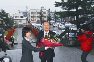 初登庁で職員から花束を受け取る谷井市長の写真