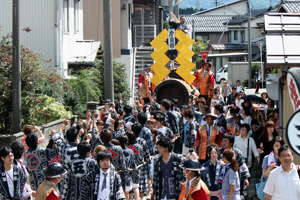 元気良く花火の筒を引く若者の画像