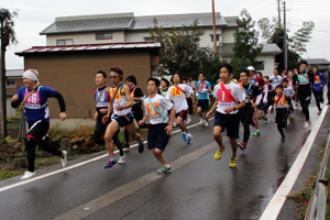 雨の中、スタートダッシュをする選手の画像