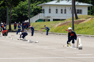 素早くホースをつなぐ消防隊員の画像