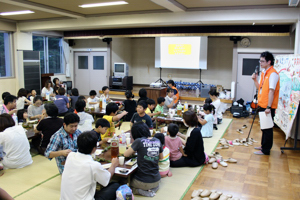 食べながら防災紙芝居を聴く参加者の画像