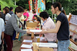 入場券付牛の角突きカレンダーをもらう来場者の画像