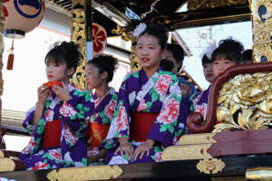 祭り屋台に乗る子どもたちの画像