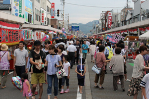 大勢の人でにぎわうおまつり広場の画像